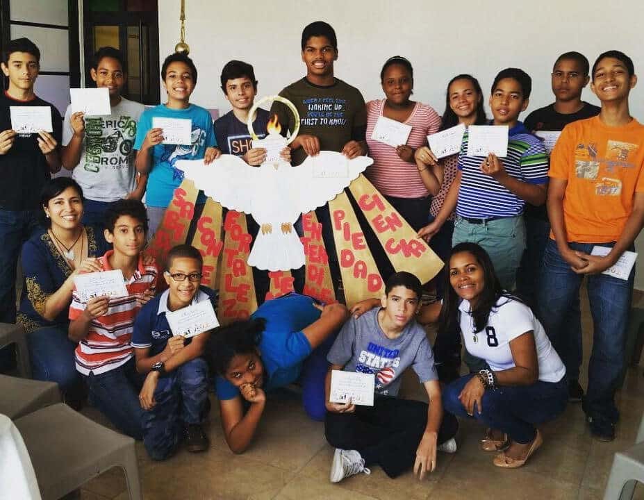 Adolescentes con su catequista y un mural del Espíritu Santo